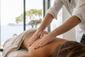 Un ostéopathe professionnel ajuste doucement le dos d'un patient allongé dans une clinique claire et apaisante à Six-Fours-les-Plages.