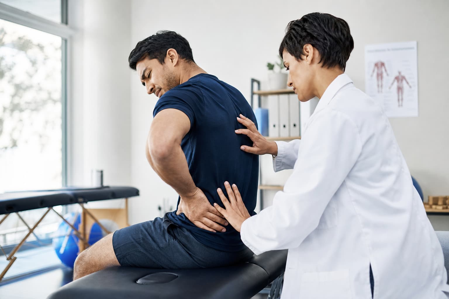 Un patient souffrant de douleurs lombaires est assis sur une chaise d